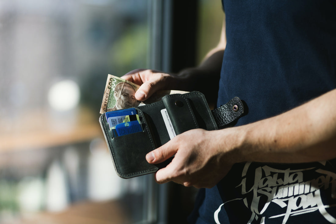 man opening wallet and taking out some money